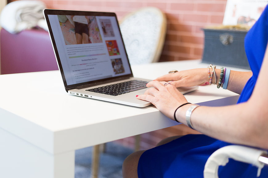 Woman Typing on Laptop at White Desk