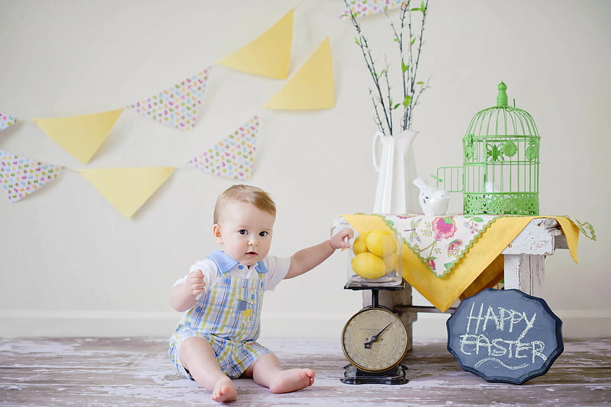 Baby Boy Sitting Near Easter Decorations and Lemons