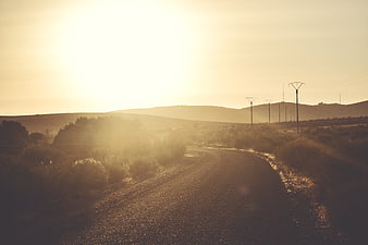 Golden Hour Rural Road with Power Lines and Hills