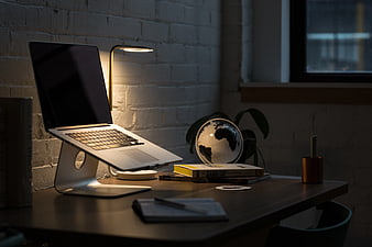 Modern Workspace with Laptop on Stand and Globe