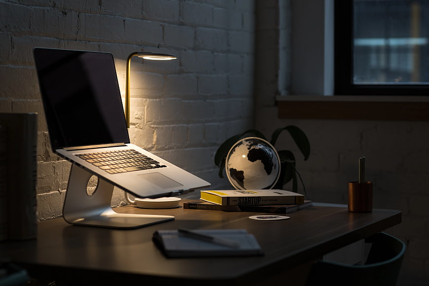 Modern Workspace with Laptop on Stand and Globe
