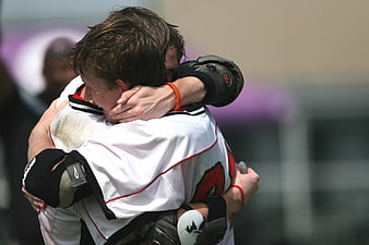 Two lacrosse players hugging in celebration