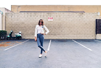 Woman in Jeans and White Jacket in Parking Lot