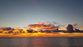 Vibrant Orange Sunset Over Calm Ocean Horizon
