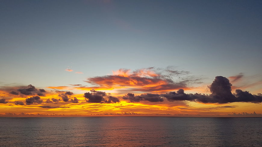 Vibrant Orange Sunset Over Calm Ocean Horizon