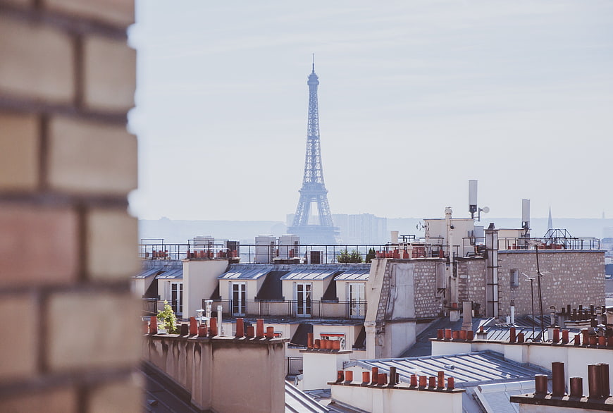 Paris Rooftops with Eiffel Tower in Hazy Background