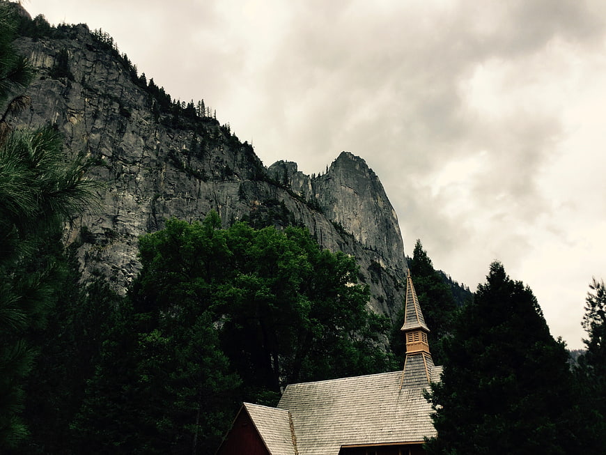 Rustic Chapel Roof Against Dramatic Mountain Cliff