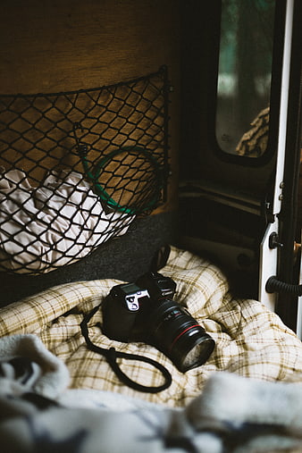 DSLR Camera on Plaid Blanket in Van Interior