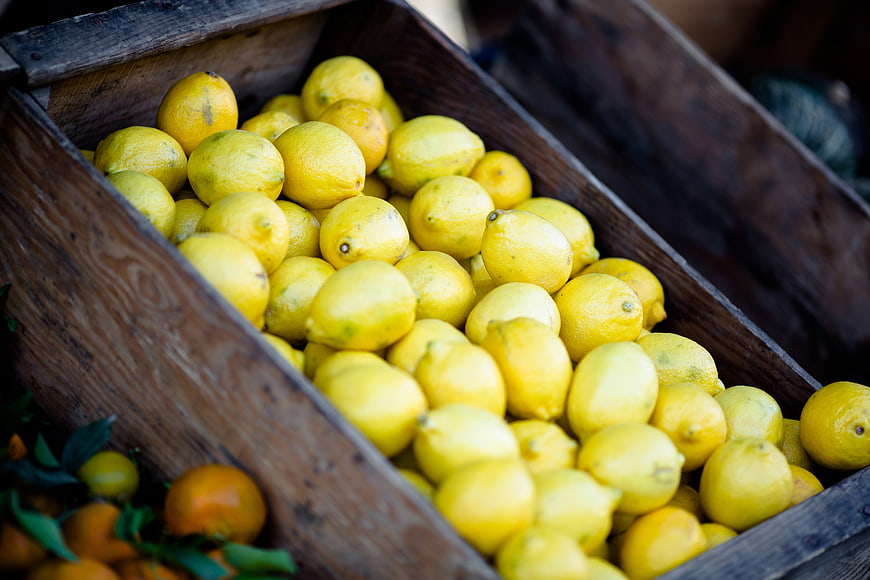 Fresh Lemons in Wooden Crate at Market