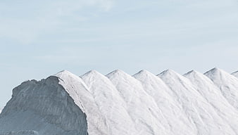 Snow-Capped Mountain Peaks Against a Pale Blue Sky