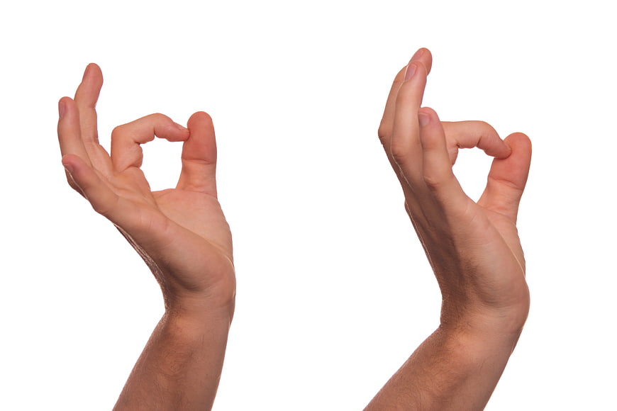 Hands making OK sign gesture on white background