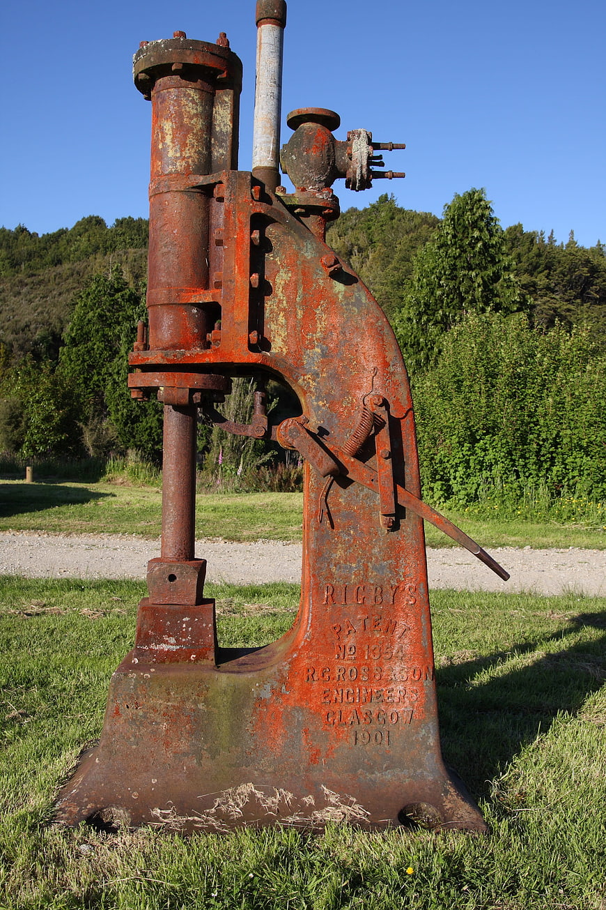 Rusty vintage industrial pump in a grassy field