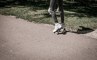 Close-up of legs roller skating on a paved path