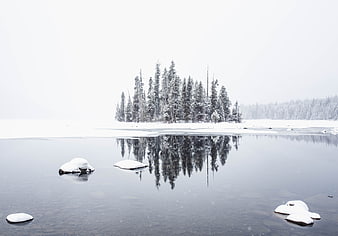Serene Winter Landscape with Snowy Island Reflection in Frozen Lake