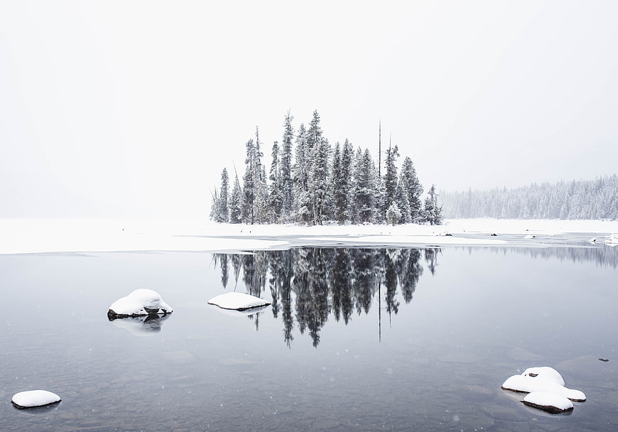 Serene Winter Landscape with Snowy Island Reflection in Frozen Lake