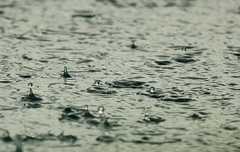 Close-up of raindrops splashing on water surface