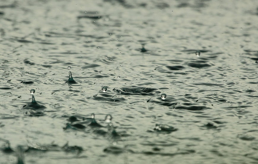Close-up of raindrops splashing on water surface