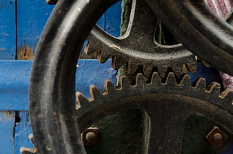 Close-up of vintage rusty gears against blue wood