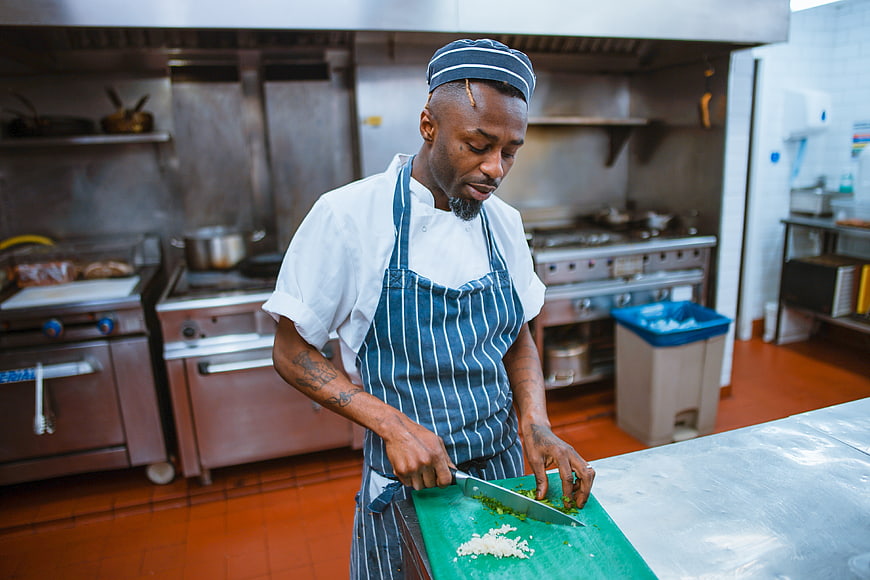 Professional Chef Chopping Vegetables in Commercial Kitchen