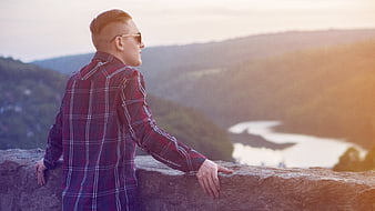 Man in Plaid Shirt Looking at Scenic River Valley Sunset