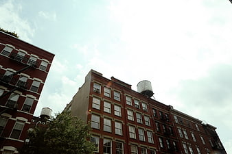 Low angle view of red brick apartment buildings with water tanks