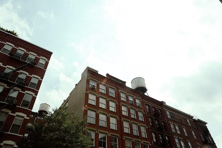 Low angle view of red brick apartment buildings with water tanks