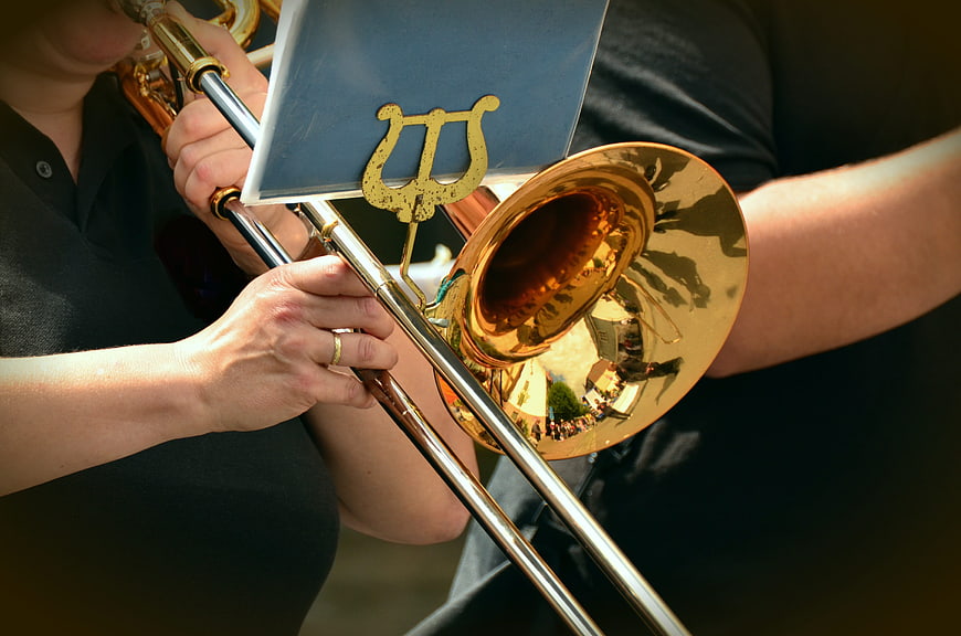 Close-up of brass trombone bell and musician hands