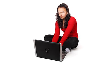 Young woman in red sweater using laptop on white background