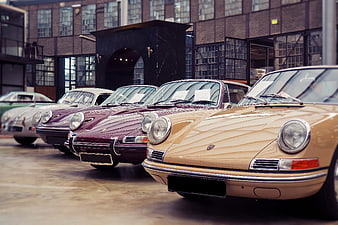 Row of vintage Porsche 911 classic cars parked in industrial courtyard