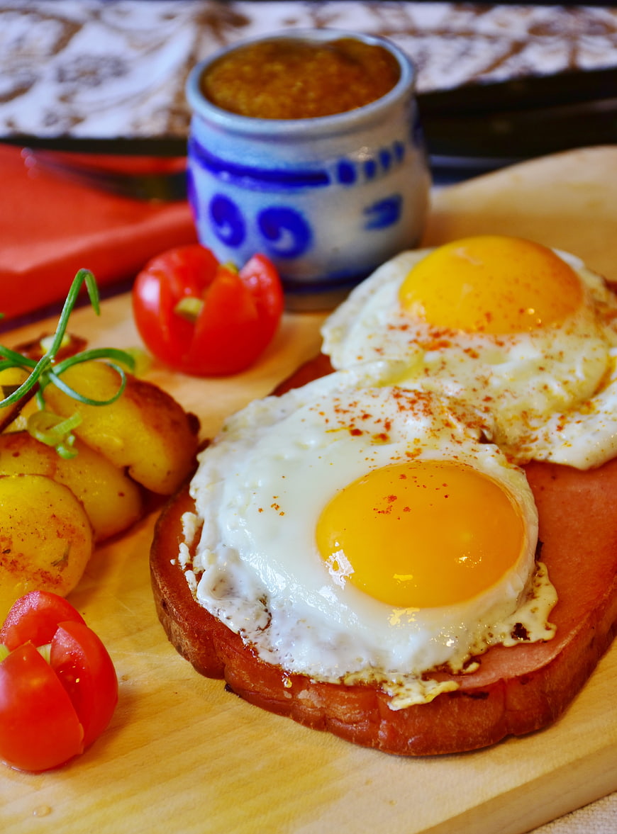 Fried eggs on toast with roasted potatoes and tomatoes
