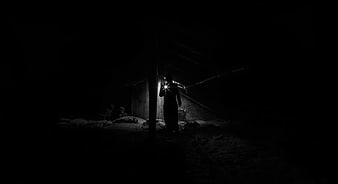 Silhouette of Man with Flashlight in Dark Attic