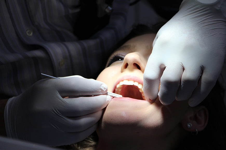 Close-up of dentist examining patient's teeth with dental tools