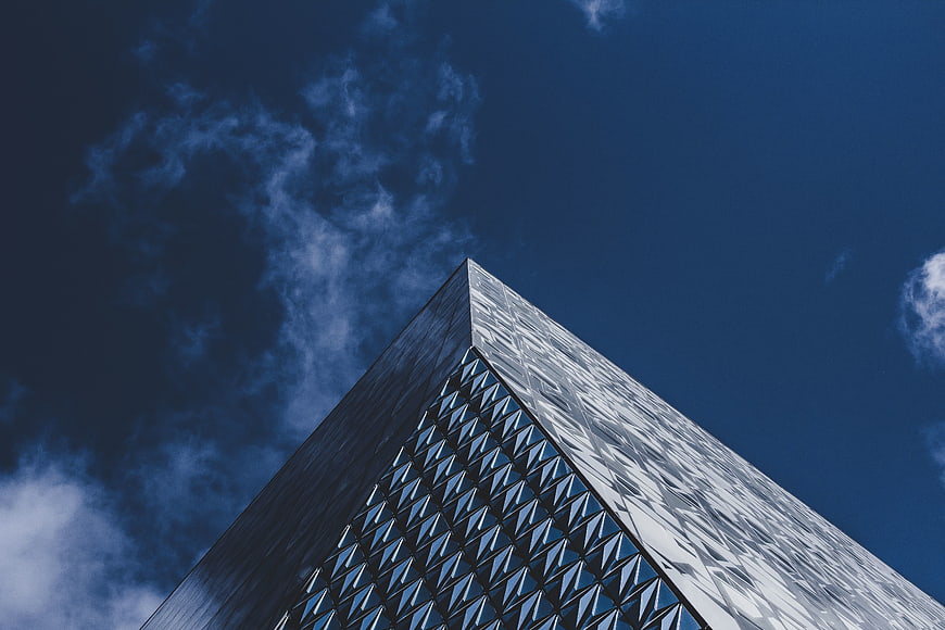 Low angle view of modern skyscraper against blue sky