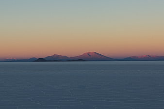 Frozen Lake Landscape with Distant Mountains at Sunset