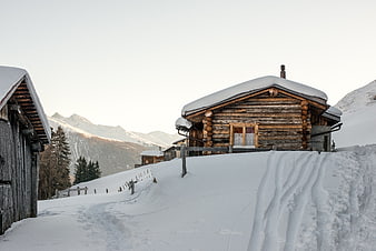 Snowy wooden chalet in alpine winter landscape