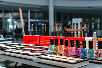 Colorful makeup display with brushes and nail polish at beauty exhibition
