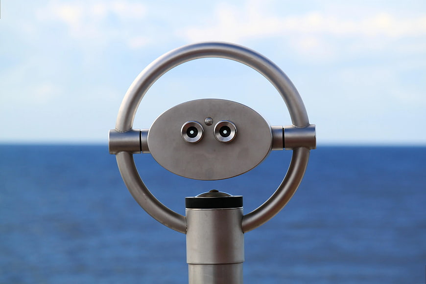 Silver Coin-Operated Telescope Facing Blue Ocean