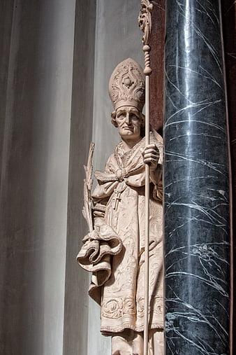 Baroque stone statue of a bishop holding a staff