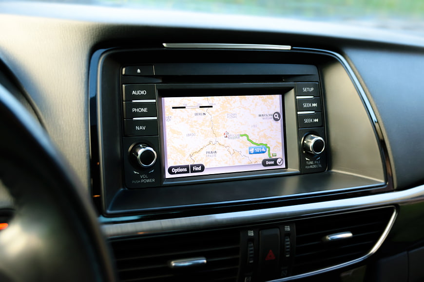 Car dashboard GPS navigation screen displaying a European road map