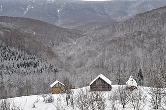 Snow-covered wooden cabins in a winter mountain valley
