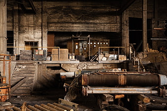 Abandoned industrial factory interior with rusty machinery and control panel