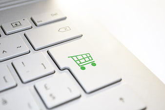 Green Shopping Cart Icon On White Laptop Keyboard Close Up