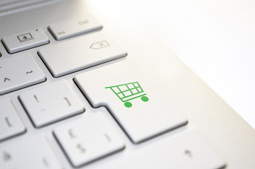 Green Shopping Cart Icon On White Laptop Keyboard Close Up