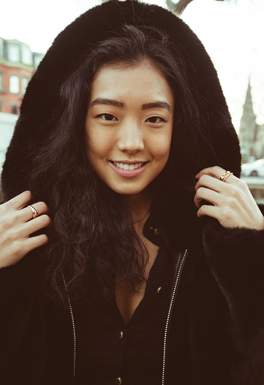Smiling Asian Woman in Black Hooded Coat Portrait