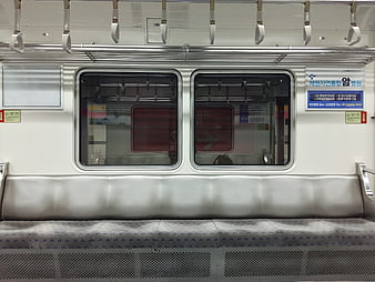 Empty subway car interior with metal seats and windows