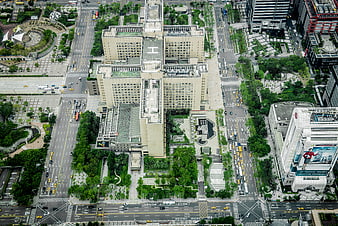 Aerial View of Urban Cityscape with Green Rooftops and Traffic