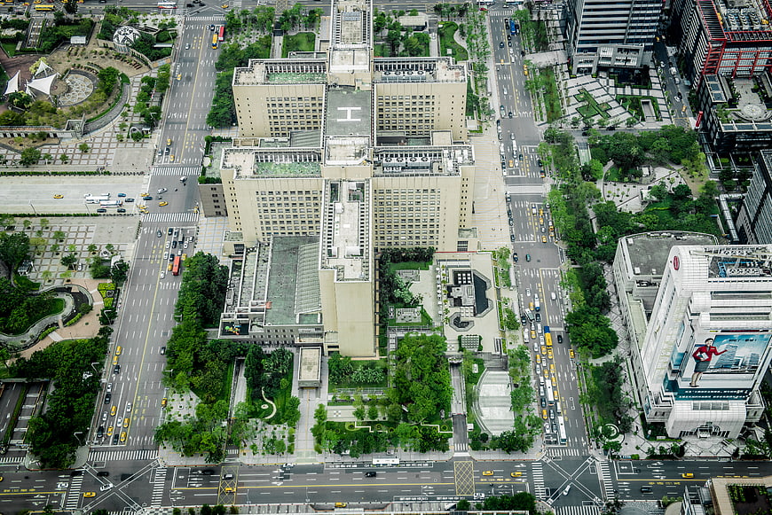 Aerial View of Urban Cityscape with Green Rooftops and Traffic