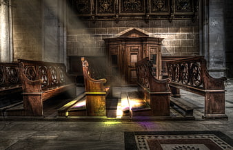 Sunbeams illuminating wooden pews in an empty cathedral interior