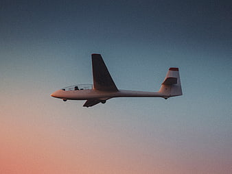 White Glider Soaring in Sunset Sky
