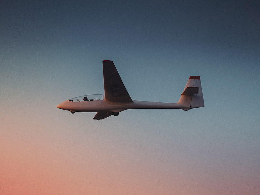 White Glider Soaring in Sunset Sky